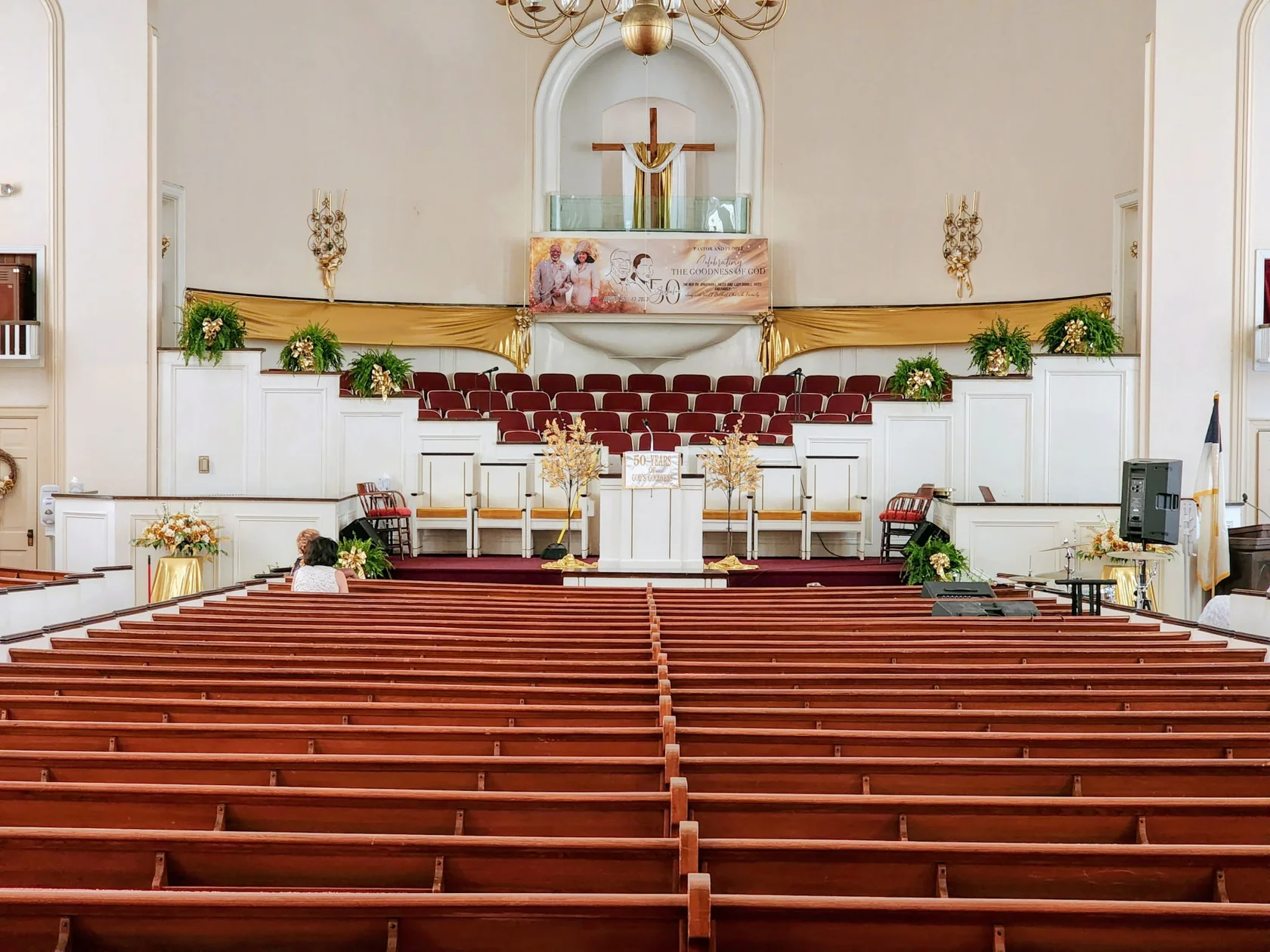 Interior of El Bethel's sanctuary with wooden pews, pulpit and cross